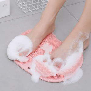 "A person's feet standing on a textured silicone non-slip shower mat with soapy lather in a bathroom."
